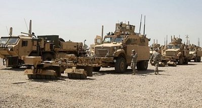 Quân đội Mỹ đứng kế bên quân xa trong một chiến dịch hậu cần thanh toán trang thiết bị và máy móc nặng ở căn cứ quân sự Balad, bắc Baghdad