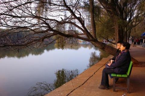 Hai du khách nghỉ chân và ngắm cảnh hồ.