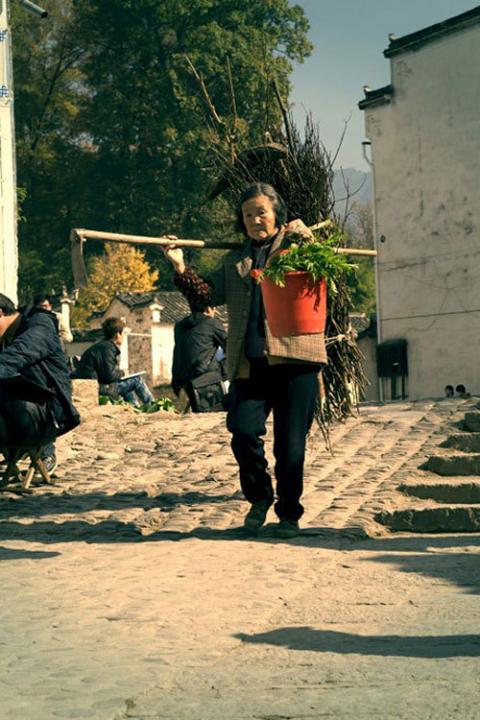 Bà cụ đi kiếm củi, hái rau trở về nhà.