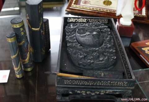 Bộ nghiên mực còn nguyên vẹn với nghiên mực lưỡng long tranh châu, đi kèm theo là 5 thỏi mực tàu, bút viết và giá đỡ bằng gỗ mun được chạm khắc tinh xảo.