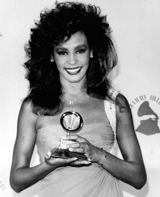 26/2/1986, Whitney chụp cùng tượng Grammy tại lễ trao giải ở Los Angeles. Cô giành giải Nữ ca sĩ trình diễn pop xuất sắc nhất cho ca khúc “Saving all my love for you”