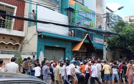 Một căn nhà trên đường Nguyễn Biểu (quận 5) tổ chức thả tiền để các nhóm thanh niên phía dưới nhặt.
