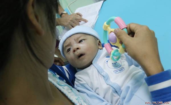 Bé Phát nằm ngoan trong tay mẹ - Ảnh: Nguyên Mi