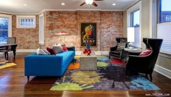 Căn phòng với tường gạch thô mộc trở nên sinh động hơn nhờ tấm thảm giống bảng màu của các họa sĩ.