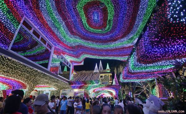 Khách tham quan đi dọc theo khu phức hợp được trang trí hàng nghìn bóng đèn tại thành phố Cainta, tỉnh Rizal của Philippines. (Ảnh: AP)
