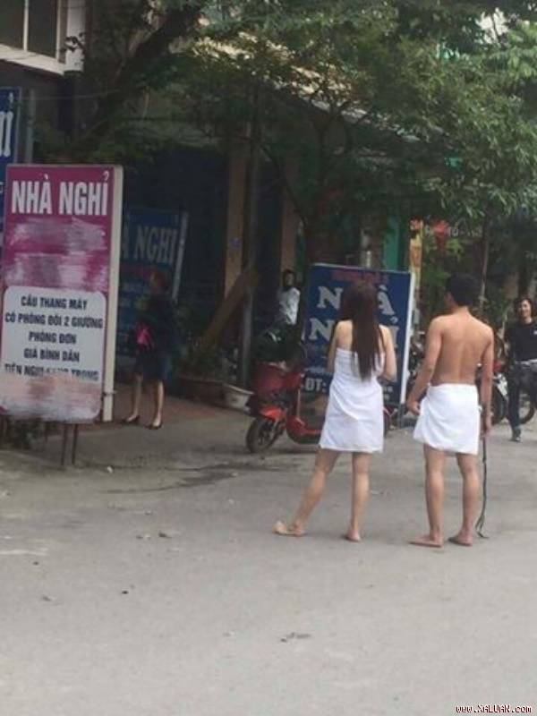 Chàng trai và cô gái chạy ra từ nhà nghỉ, trên người chỉ quấn một chiếc khăn tắm.