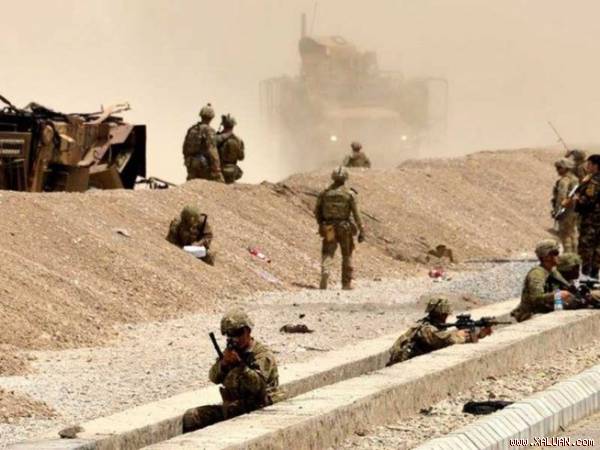 Lính Mỹ canh gác gần xác một chiếc xe của họ bị Taliban đánh bom tự sát ở Kandahar (Afghanistan) đầu tháng 8.