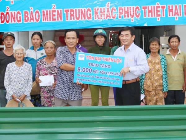 Ông Nguyễn Thanh Nghĩa (thứ 3 từ phải sang) trao tôn cho bà con tại vùng tâm bão xã Vạn Hưng, Vạn Ninh, Khánh Hòa