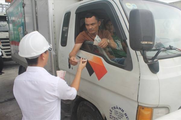 Tài xế này đưa một lốc tiền lẻ, mệnh giá 500 đồng cho nhân viên trạm BOT Ninh An đếm. Ảnh: Nhiệt Băng