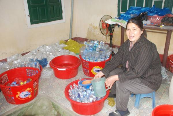 Bà Châu Thị Loan đang chế biến dấm bằng nước lã và chất axit acetic.