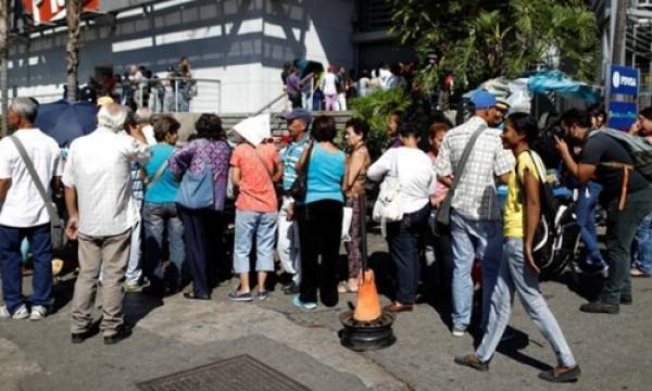 Người Venezuela xếp hàng bên ngoài một siêu thị ở thủ đô Caracas. Ảnh: Reuters