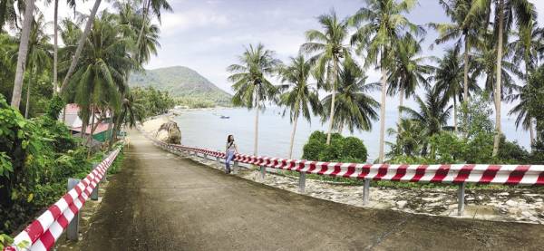 Một con đường dẫn vào ấp ở Lại Sơn được bao bọc bởi dừa, biển và núi.