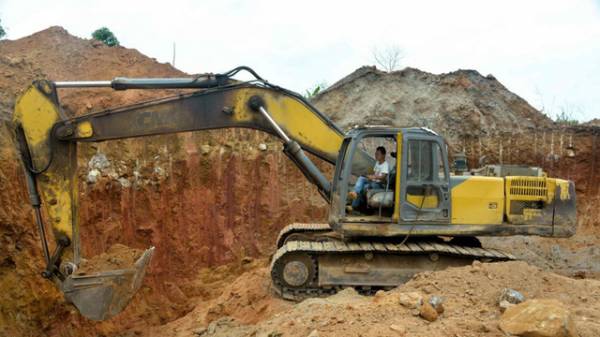 Một công nhân Trung Quốc lái máy xúc trong khu vực khai thác vàng ở Cameroon ()