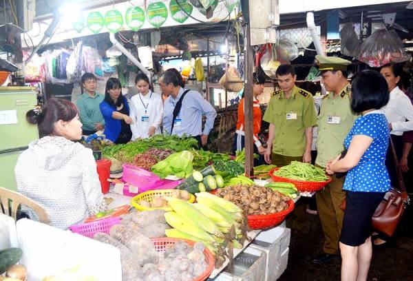 Lực lượng chức năng kiểm tra an toàn thực phẩm tại một chợ truyền thống. (Ảnh: Nhật Minh).