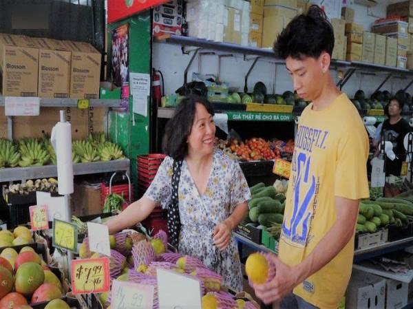 Chị Hà dẫn cậu con trai lớn đi mua đồ chuẩn bị cho bữa cơm tất niên.