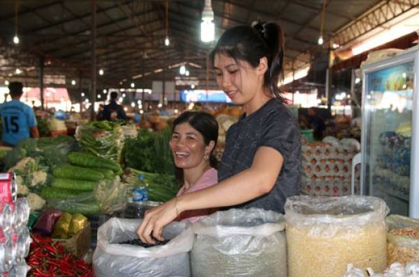 Nguyễn Thị Kim Nga (đứng), đang buôn bán tạp hóa tại chợ Talat lacxam, tỉnh Attapeu