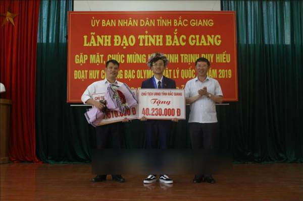 Phó Chủ tịch Lê Ánh Dương trao Bằng khen của Chủ tịch UBND tỉnh và phần thưởng hơn 40,2 triệu đồng cho em Hiếu.