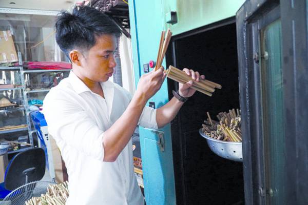 Anh Nguyễn Văn Mão, Giám đốc Công ty TNHH Sáo trúc Mão Mèo kiểm tra lại chất lượng ống hút tre sau khi được sấy ở nhiệt độ 120 độ C