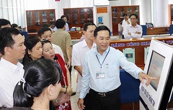 Cán bộ tư pháp hướng dẫn người dân tra cứu thông tin, giải quyết thủ tục hành chính tại Trung tâm giải quyết thủ tục hành chính tỉnh Cà Mau. Ảnh: QUỲNH ANH