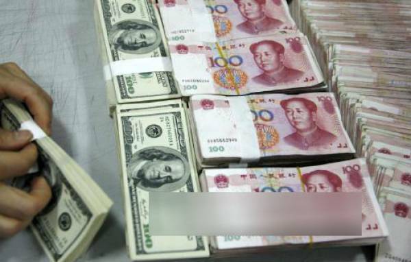Kiểm tiền NDT (phải) và USD (trái) tại ngân hàng ở tỉnh An Huy, Trung Quốc.