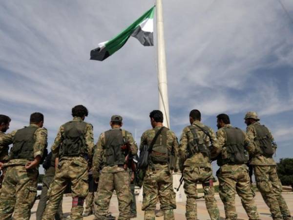 Các tay súng nổi dậy Syria được Thổ Nhĩ Kỳ hậu thuẫn treo cờ của phe đối lập Syria tại thị trấn biên giới Tal Abyad. Ảnh: REUTERS