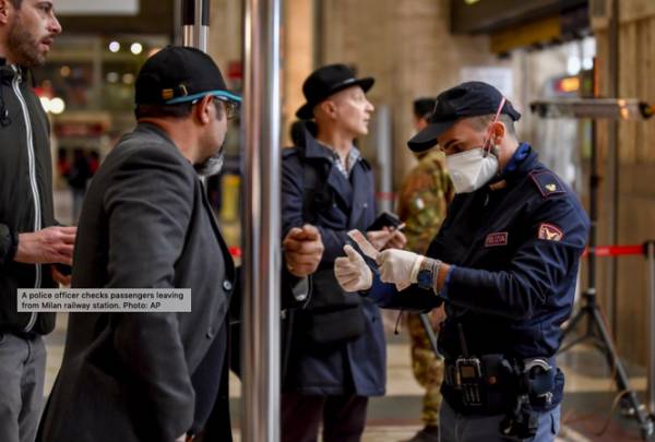 Cảnh sát kiểm tra hành khách tại một nhà ga ở Milan. (Ảnh: AP)